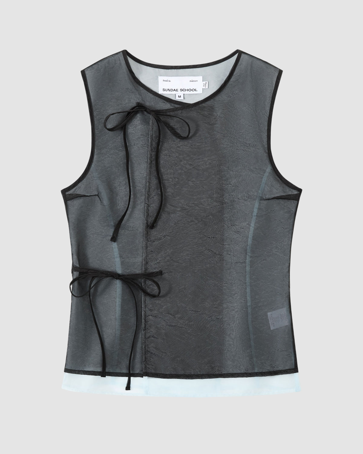 The BLACK VITA ORGANZA VEST by Sundae School is a sleeveless sheer black mesh top with black trim and Korean goreum ties at neck and side. A white label is visible at the neck. Displayed on a plain light gray background.