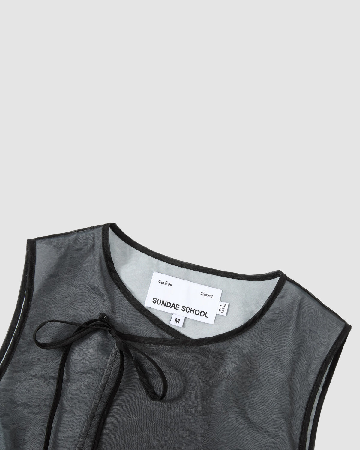 The BLACK VITA ORGANZA VEST by Sundae School is a sleeveless, sheer black over sky blue top featuring a Korean goreum tie neckline, black trim, and an inner white label with 