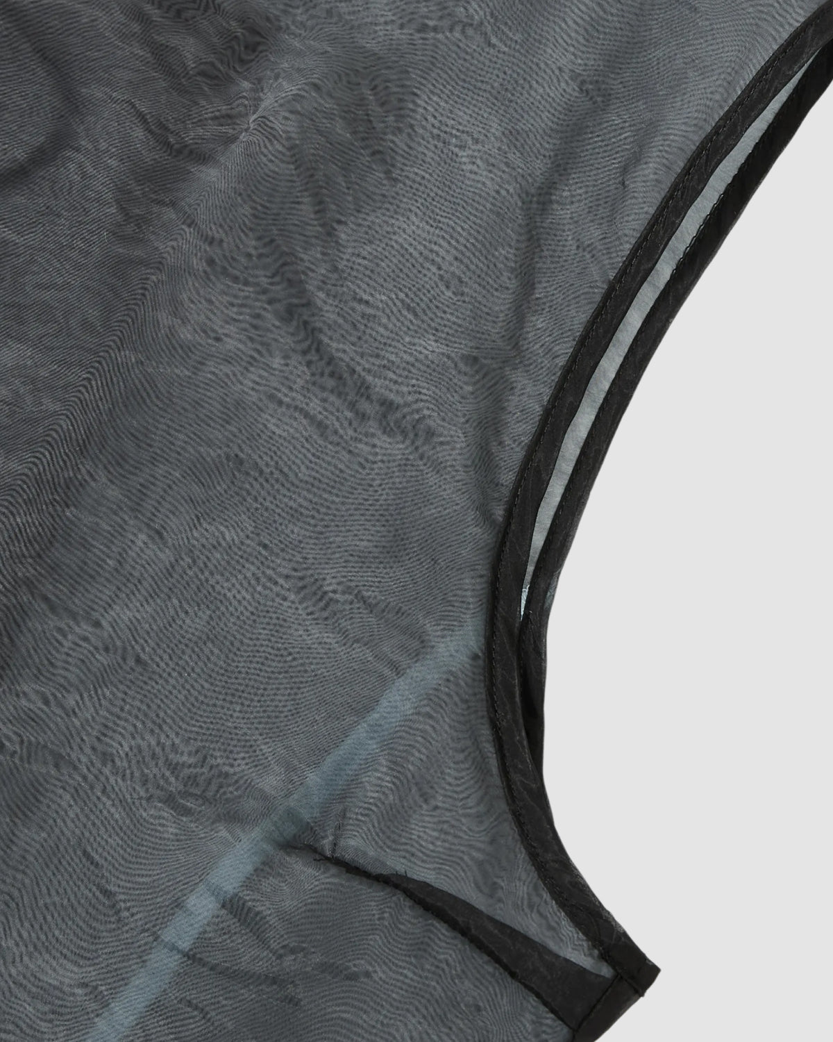 Close-up of Sundae School's BLACK VITA ORGANZA VEST shows sheer black over sky blue mesh, visible stitching, and an armhole opening, evoking a double-layered effect against a light gray background.